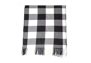 Detail of classic black and white buffalo plaid pattern with fringe on soft winter shawl