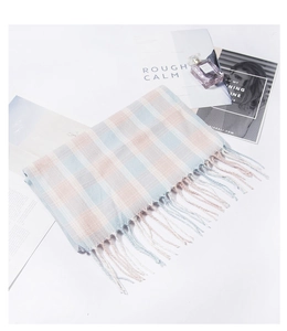 Dettaglio di morbida sciarpa a quadri con frange, texture in maglia azzurra e rosa