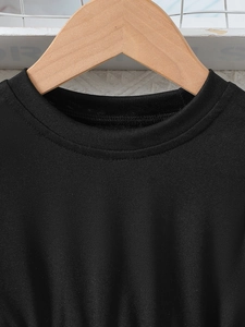 Close-up of a black round neck cotton t-shirt for girls featuring premium reinforced stitching