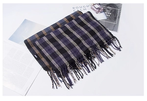 Dettaglio della trama della sciarpa a quadri con frange nei toni viola, giallo e nero