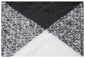 Makro-Detail des weichen schwarz-weißen Karostricks und der dicken Textur des Schals