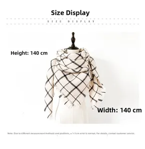 Detail of oversized black and white plaid scarf featuring soft fringe and 140x140cm dimensions