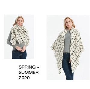 Detail of cream and black checkered cashmere-like scarf showing soft fringe and shawl drape