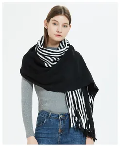 Close-up of black and white striped knitted scarf with fine frayed edges and soft texture