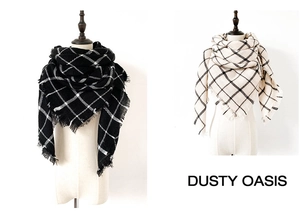 Detail of checkered cashmere-like scarves with fringe edges on cream mannequins