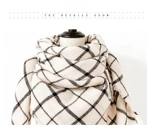 Close-up of beige plaid scarf showing soft fabric texture and fashionable frayed edges