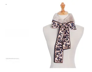 Close-up of faux fur scarf with leopard print silk ribbon on a white mannequin