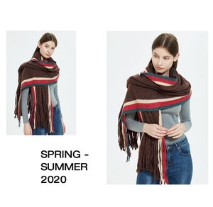 Detail of colorful striped knitted scarf with long tassels in coffee red and green