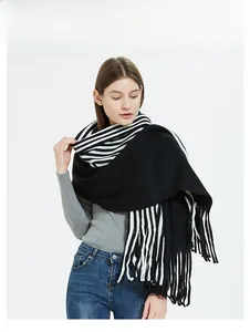 Close-up of black and white striped knit scarf with long tassels and thick wool texture