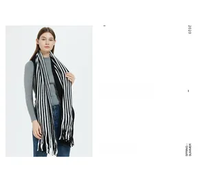 Detail of black and white striped knit scarf with classic long fringed edges