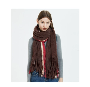 Close-up of thick knitted scarf with dark brown stripes and soft long tassels