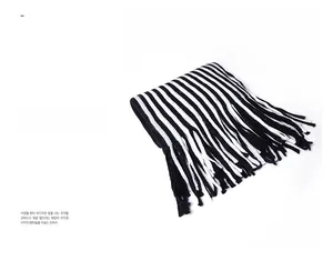 Close-up of black and white striped knit scarf with soft fringe trim details
