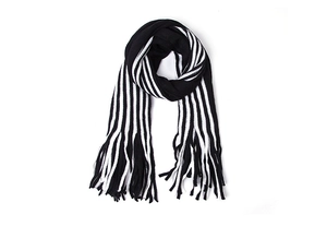 Close-up of black and white striped knit scarf featuring classic fringe tassel details