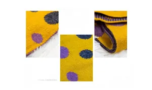 Close-up of mustard yellow knitted scarf with large purple and blue polka dot patterns