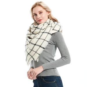 Beige and black checkered oversized scarf with tassel edges worn by a model