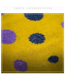 Close-up of soft yellow knit fabric featuring purple and blue polka dots and fine texture