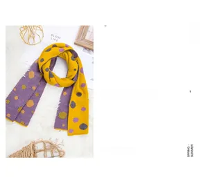 Close-up of soft yellow and purple polka dot knit scarf on a plush faux fur backdrop