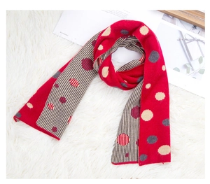 Detailed knit texture of red polka dot winter scarf with gray and beige stripes