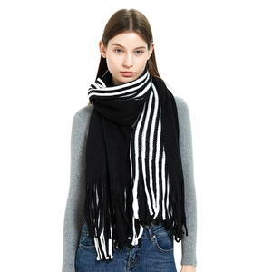 Classic black and white striped knit scarf with fringe tassels worn by model