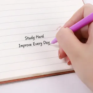 Hand holding a purple alpaca gel ink pen writing on a minimalist lined notebook