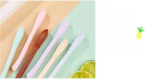 Dettaglio di penne a forma di scopa in colori pastello con tappo a trama piumata