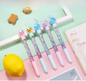 Detail of five liquid glitter pens with cartoon toppers like cat ears and blue moons