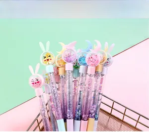 Close-up of glitter pens with cartoon toppers in a gold wire basket on pastel background