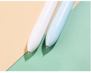 Detail of white and blue macaron ballpoint pens with minimalist metal nibs and plastic bodies