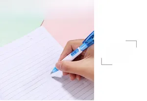 Détail d'une main écrivant avec un stylo à bille LED bleu de 0,7 mm sur du papier
