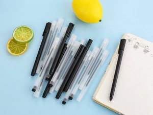 Close-up of frosted black and translucent gel pens with a lifestyle setup on blue background