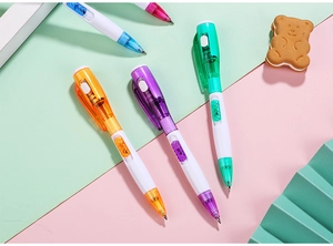 Détail de stylos à bille colorés avec lampe LED dans un décor de papeterie pastel