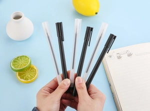 Detailed close-up of a 5-piece minimalist neutral pen set in a fresh office desk setting