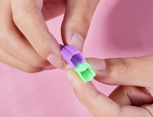 Macro shot of colorful plastic interlocking joints for building blocks on pink background