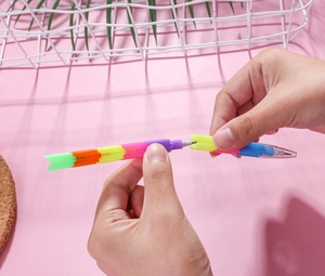 Detail showing hands assembling a multi-color building block stacking pencil for students