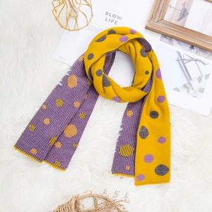 Winter knit polka dot scarf in purple and yellow on a cozy white plush background