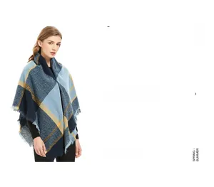 Gros plan d'une écharpe à carreaux bleus et jaunes avec franges et texture douce