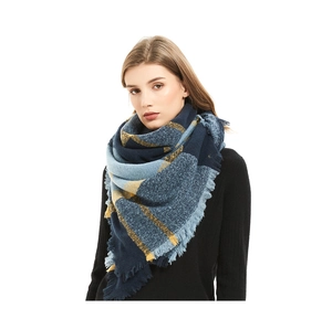 Gros plan sur l'écharpe à carreaux bleu et jaune avec tricot épais et détails de franges