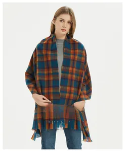 Detail of soft plaid scarf with fringe in blue, orange and brown woven pattern