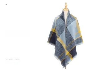 Détail de la texture de l'écharpe à carreaux bleu et marron avec franges et tricotage