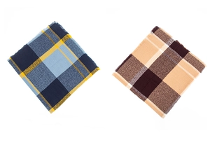 Gros plan d'écharpes à carreaux bleus et marrons avec franges sur fond blanc