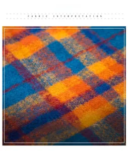Macro detail of plaid winter scarf fabric in orange, dark blue and yellow check patterns