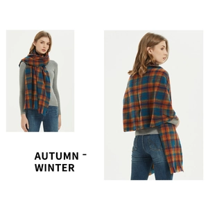 Detail of plaid scarf featuring orange and navy patterns with soft fringe edges