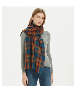 Close-up detail of classic vintage plaid scarf in orange, blue and teal fringe wool fabric