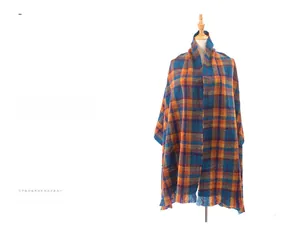 Detail of soft plaid scarf featuring deep blue, orange, and dark red checkered patterns
