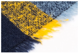 Gros plan sur une écharpe en maille à carreaux bleus et jaunes avec franges douces