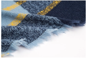 Vue détaillée de l'écharpe en maille à carreaux bleus et jaunes avec bords à franges