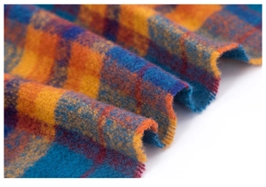 Macro shot of warm plaid fabric showing brushed soft texture in orange and blue