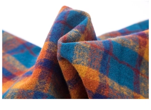 Close-up of thick brushed plaid fabric in vibrant blue, orange, and purple hues