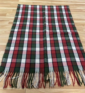 Detailed view of the red and green plaid scarf featuring soft fringes and a classic pattern