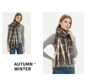 Detail of classic plaid scarf with fringe in brown and navy blue autumn winter knit